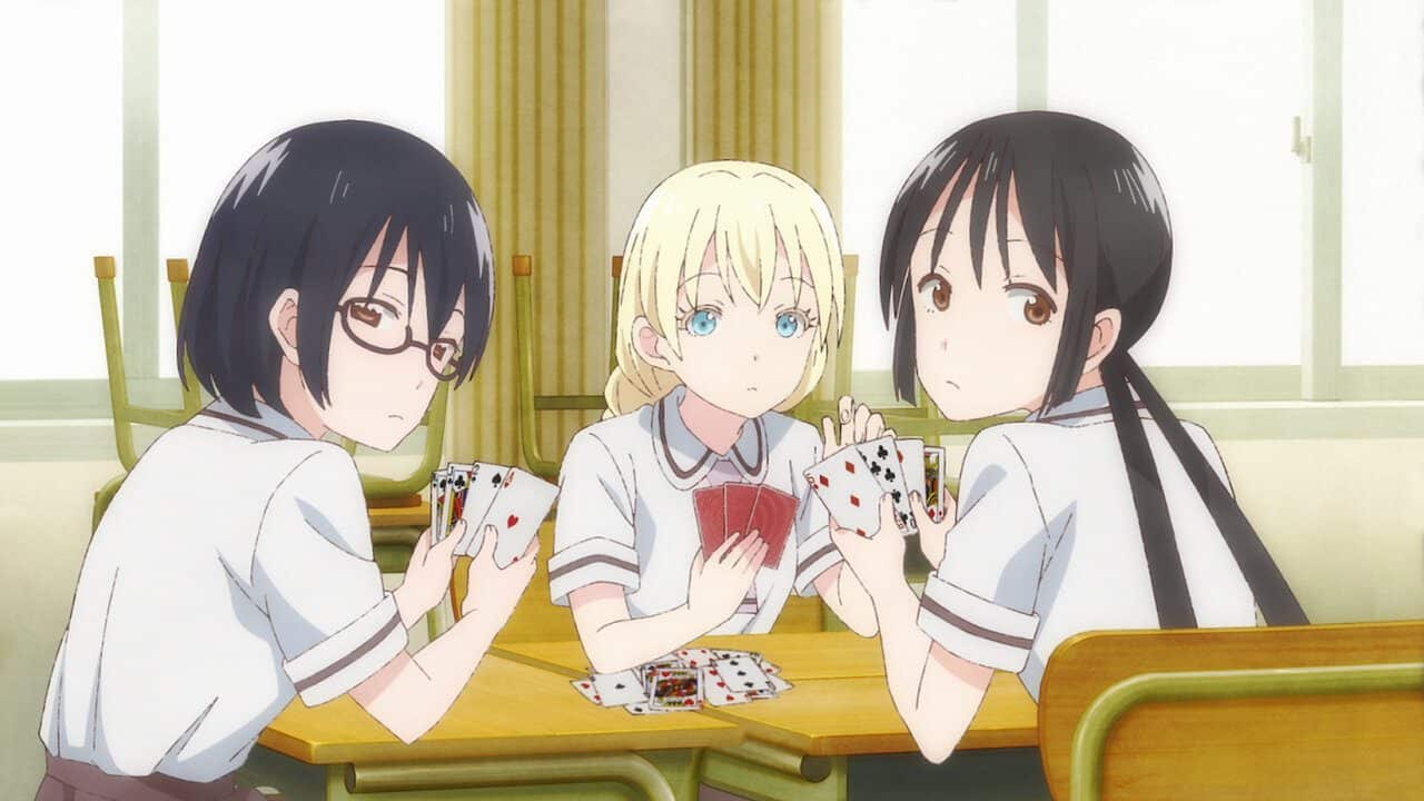 three school girls playing cards