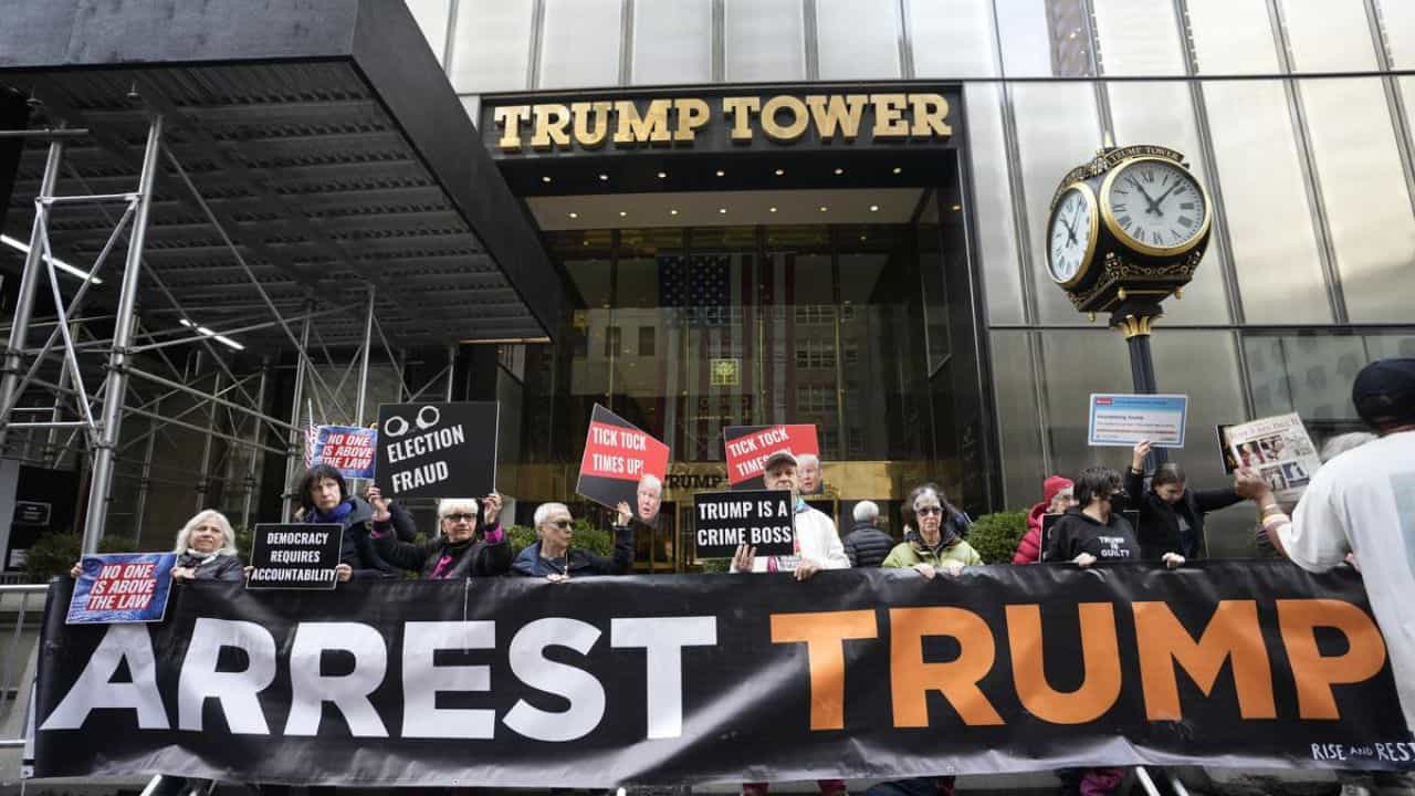 Protesters protest with "Arrest Trump" banner in front of Trump Tower