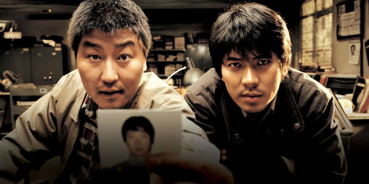 two detectives pointing a photo to the screen