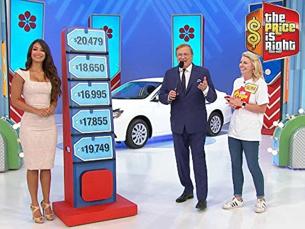 Manuela, in a still from The Price is Right, alongside host Drew Carey. 