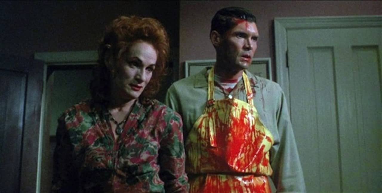 The adulterous siblings from the movie covered in blood standing side by side