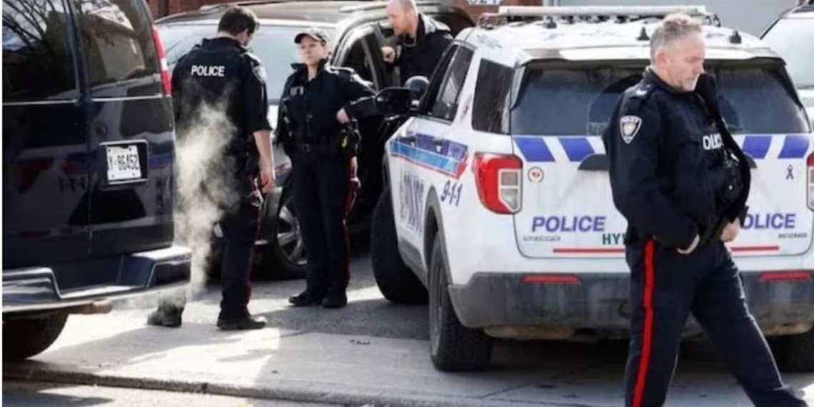 Ottawa Police Service officers surround a home following the mass murder case (Credit: Reuters)