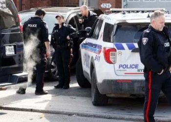 Ottawa Police Service officers surround a home following the mass murder case (Credit: Reuters)