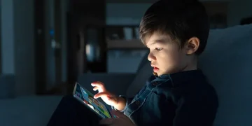 young boy using a digital tablet (Image via Getty)