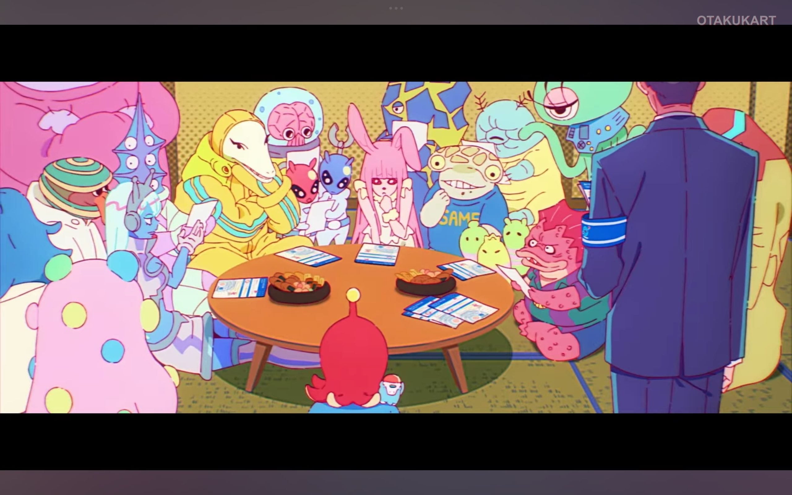 Colorful alien characters gather around a table during a meeting in the Grotesqqque anime trailer.