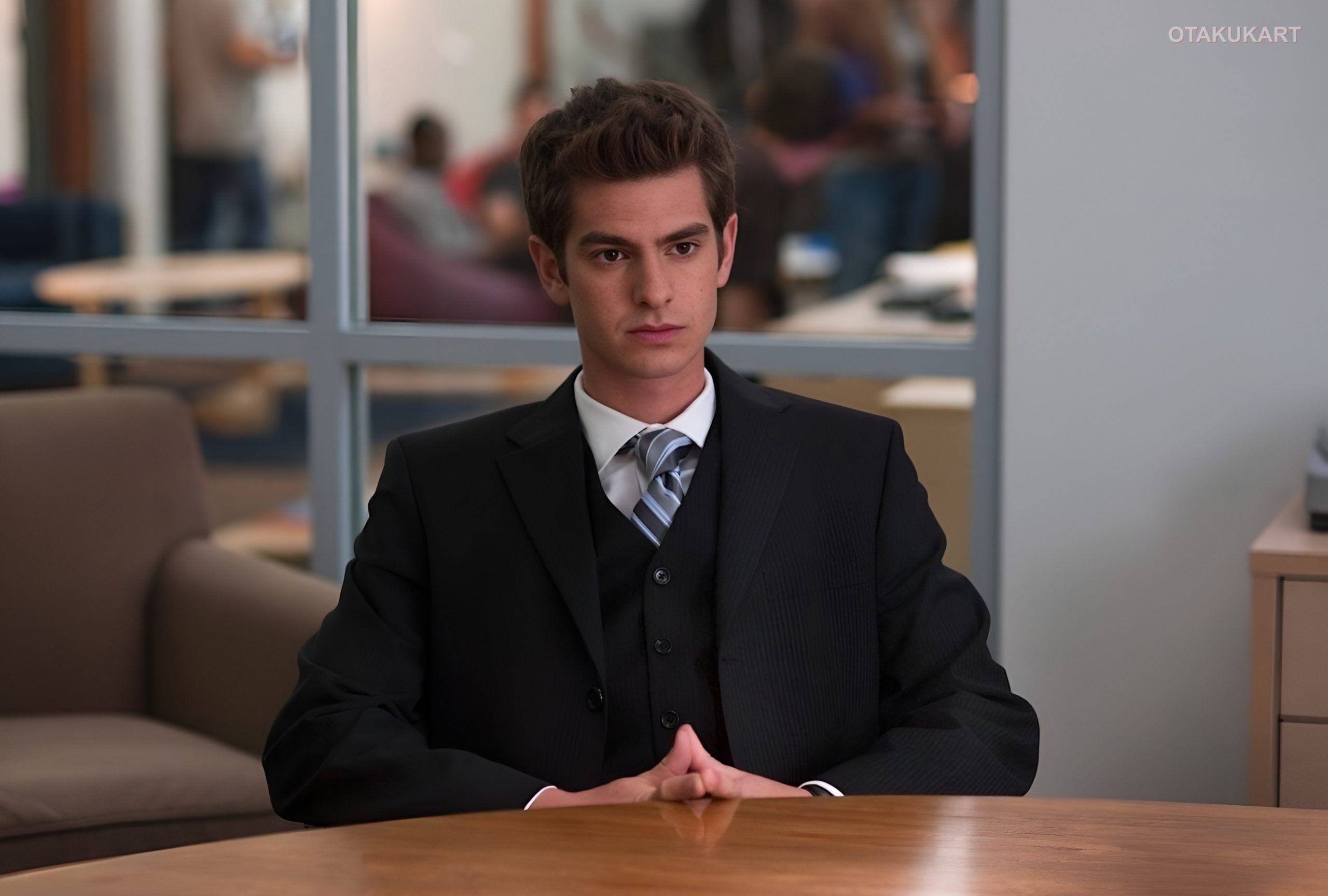 Andrew Garfield as Sam Altman in Artificial, seated in an office.